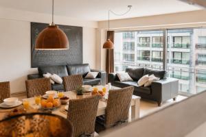 a living room with a table and a couch at Vertry at Sea, Luxury Apartment Knokke in Knokke-Heist