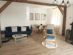 a living room with a blue couch and a table at La Maison bleue Paissy in Paissy