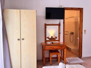 a bathroom with a wooden table and a mirror at Villa Xenia in Ammoudia