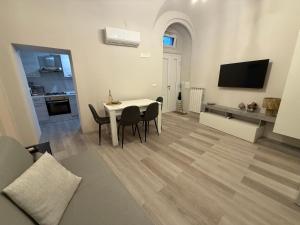 a living room with a table and chairs and a television at Ad un Passo dal Duomo in Bovino +25 photos