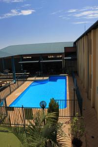 a large blue swimming pool next to a building at Ningaloo Coral Bay Backpackers in Coral Bay