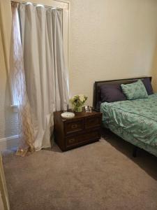 a bedroom with a bed and a table and a window at Plantlife LLC Lodge U room in Minneapolis