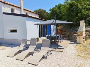 a group of chairs and a table and an umbrella at Casa Bellea in Belej