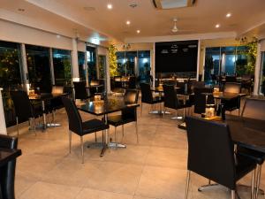 a restaurant with tables and chairs and windows at ibis Styles Broken Hill in Broken Hill