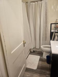 a bathroom with a toilet and a white door at Plantlife LLC Lodge U room in Minneapolis