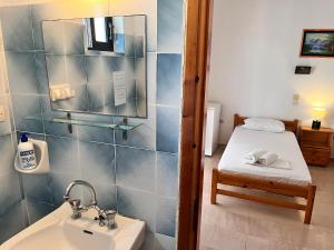 a bathroom with a sink and a bed in a room at Villa Xenia in Ammoudia