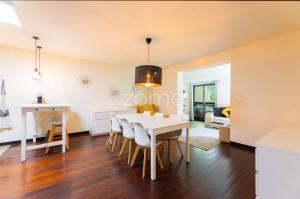 a dining room and living room with a table and chairs at Casa da Lagoa II in Terras de Bouro