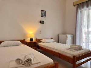 a room with two beds and a refrigerator at Villa Xenia in Ammoudia