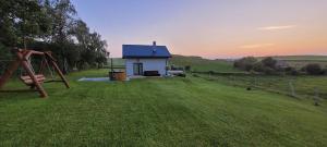 a small house in a field with a playground at Domek na Szczycie u Basi in Udryń