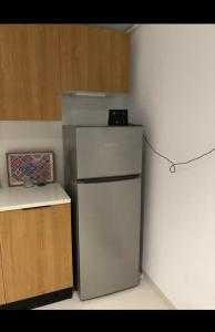 a small refrigerator in a kitchen with wooden cabinets at Studio Hergla in Sidi Bou Ali