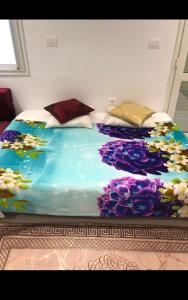 a bedroom with a bed with flowers on it at Studio Hergla in Sidi Bou Ali