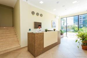 a man standing at a counter in a lobby at Hotel Scorpio gonio in Gonio
