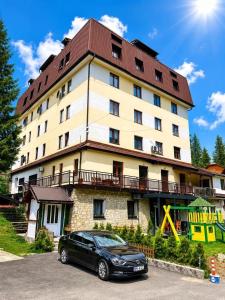 a car parked in front of a large building at Alpin Wellness & Spa Vlašić in Vlasic