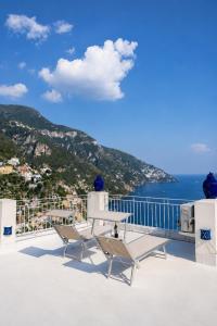 a balcony with two chairs and a view of the ocean at Love in Blue - La Terrazza di Positano in Positano