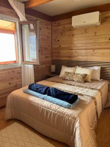 a bedroom with a bed in a room with wooden walls at Pedra Douro in Fontelas