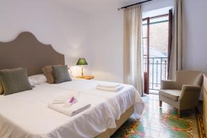 a bedroom with a large white bed and a chair at Villa Ca na Marrona - Sunset Villa Campanile in Sa Pobla +43 photos