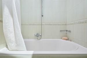 a bath tub with a shower with a shower curtain at Hedera Estate Hedera A34 in Dubrovnik +27 photos