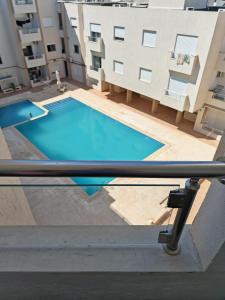 a view of a swimming pool from a balcony of a building at superb appartement in Kelibia