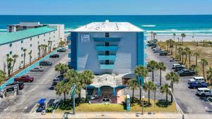 a large blue building with a parking lot next to the ocean at Luxury Beach Condos with Pool and Tiki Bar! in Daytona Beach