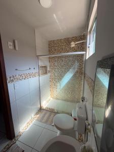 a bathroom with a toilet and a glass shower at Paraíso Oculto in Carolina +10 photos