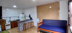 a kitchen with a blue couch in a room at 001 1 Dormitorio Centro Bombinhas 400 m da praia in Bombinhas