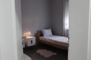 a small bedroom with a small bed and a night stand at Villa Martar in Mostar