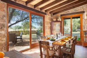 a dining room with a table and a large window at Sunset private Eco-Villa Can Vey in Inca