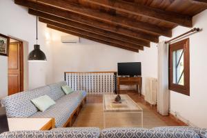a living room with a couch and a tv at Sunset private Eco-Villa Can Vey in Inca