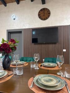 a table with plates and wine glasses and a clock on the wall at Cindrel Chalet Jina in Jina