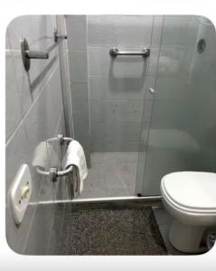 a bathroom with a toilet and a glass shower stall at Apt Icaraí Niterói Leonardo Davince in Niterói +15 photos