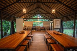 a large dining room with wooden tables and benches at Four Monkeys Eco Lodge - Jungle & Beach in Cabo Matapalo