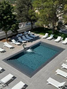 an infinity pool with lounge chairs and a swimming pool at Hotel Perla del Gargano in San Giovanni Rotondo