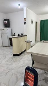 ein Zimmer mit einer Küche mit Tisch und Kühlschrank in der Unterkunft ApartWestern in Chilecito
