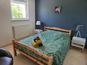a bedroom with a bed with a teddy bear on it at Gites les marronniers in Marigny