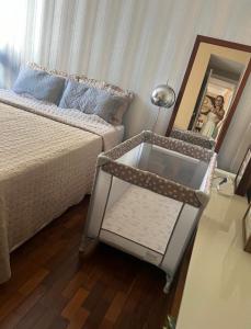 a bedroom with a bed and a mirror and a table at Apt Icaraí Niterói Leonardo Davince in Niterói