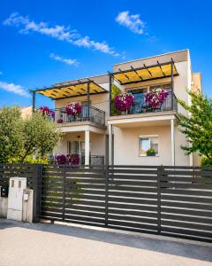 a house with flower boxes on the balconies at Apartments MENA in Bibinje