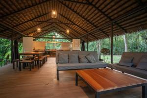a living room with couches and tables in a pavilion at Four Monkeys Eco Lodge - Jungle & Beach in Cabo Matapalo