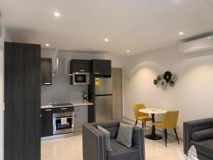a kitchen and living room with a couch and a table at The Snug Stay - Lennox in Accra