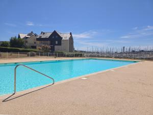 a large blue swimming pool in front of a house at Escale au Port du Crouesty in Arzon