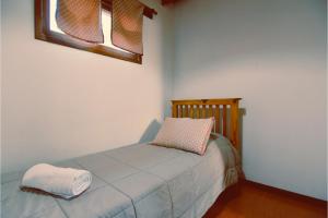 a bedroom with a bed with a pillow and a window at Complejo cabañas Portal Uritorco in Charbonier
