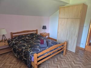 a bedroom with a bed with a black and white comforter at Gites les marronniers in Marigny +7 photos