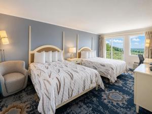 ein Hotelzimmer mit zwei Betten und einem Stuhl in der Unterkunft Cod Cove Inn, BW Signature Collection-Boothbay Harbor Area in Edgecomb + 25 Fotos