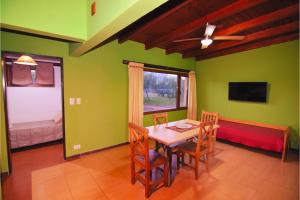 a dining room with green walls and a table and chairs at Complejo cabañas Portal Uritorco in Charbonier