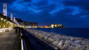 a sidewalk next to the water at night at Lo Studio della Riviera in Naples