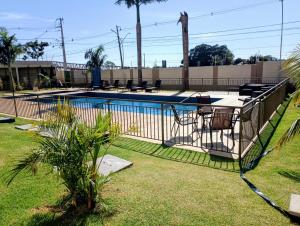 a fence around a swimming pool in a yard at Apartamento 5 minutos do parque de exposições in Maringá