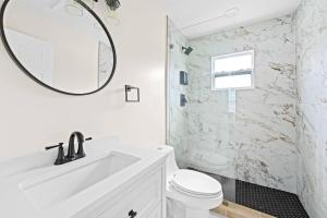 a white bathroom with a sink and a mirror at Ocean Retreat C in Boynton Beach +14 photos