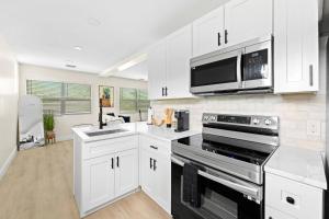 a kitchen with white cabinets and a microwave at Ocean Retreat C in Boynton Beach
