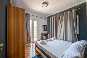 a bedroom with a bed and a large window at Vila Andrea in Himare +65 photos