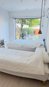 two beds in a room with a large window at Maison de Clare 메종드클레어 in Gyeongju