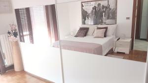 a white bedroom with a bed and a mirror at "Da Zia House Comfort e Relax vicino a Torino" in Brandizzo